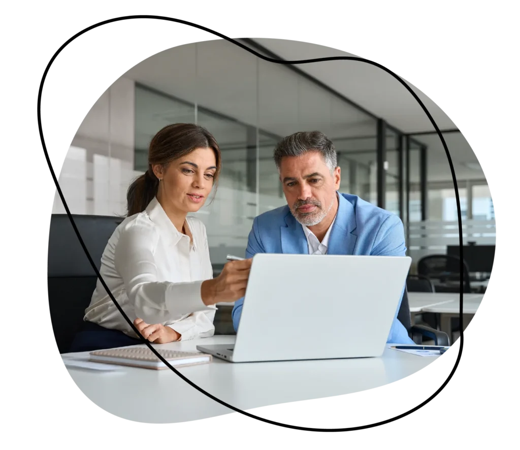 Two colleagues reviewing IT support options on a laptop